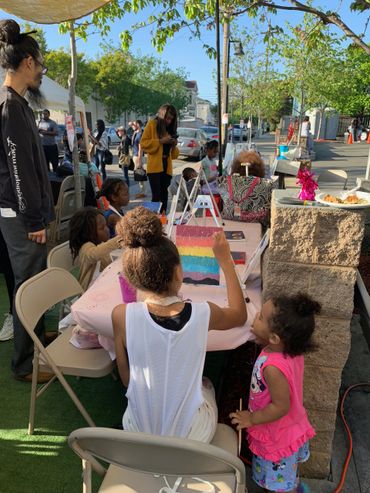 women and children painting outside