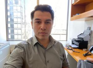 Latino male with short dark hair. He is wearing a light green shirt.